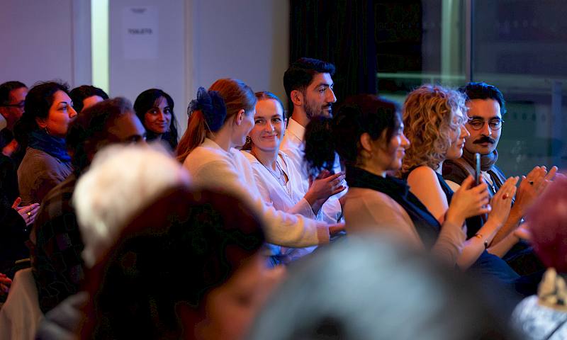 Crowd shot of audience seated and clapping
