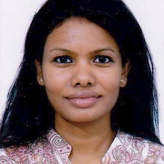Passport style photo of a person with long straight black hair. They are wearing a white and pink paisley-patterned shirt.